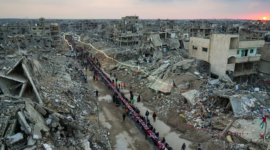 Warga Palestina duduk di meja besar yang dikelilingi puing-puing rumah dan bangunan yang hancur saat mereka berkumpul untuk berbuka puasa. (Dok. VOA Indonesia)