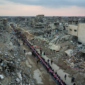 Warga Palestina duduk di meja besar yang dikelilingi puing-puing rumah dan bangunan yang hancur saat mereka berkumpul untuk berbuka puasa. (Dok. VOA Indonesia)
